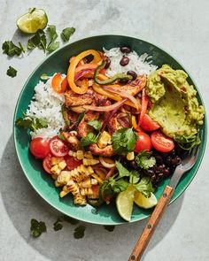 a green bowl filled with rice, vegetables and guacamole