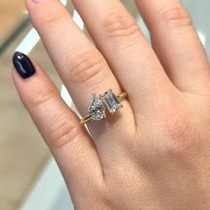 a close up of a person's hand with a diamond ring on their finger