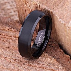 a black ceramic ring sitting on top of a piece of wood