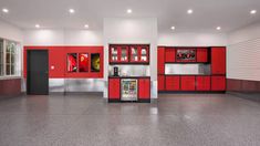 a kitchen with red cabinets and appliances in the middle of an empty floored room