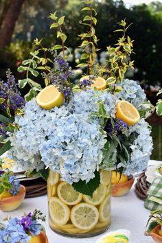 a vase filled with lemon slices and blue flowers