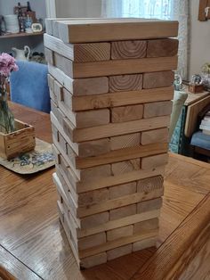 a stack of wooden blocks sitting on top of a table next to a vase with flowers