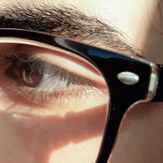 the reflection of a man's eye in some kind of black and white glasses