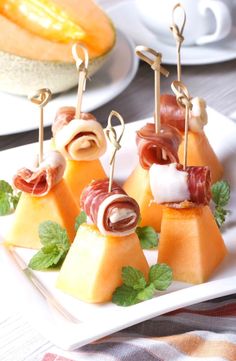 small appetizers are arranged on a plate with toothpicks stuck in them