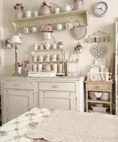 a room filled with white furniture and lots of pink decorations on the wall above it