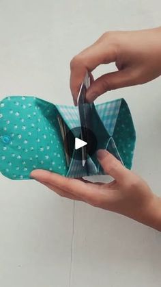 someone is holding an origami shoe in their left hand and opening it up