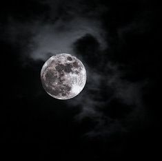 the full moon is visible in the dark night sky with clouds and black skies above it