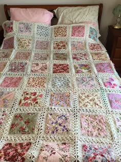 a crocheted blanket on top of a bed with pink pillows and white sheets