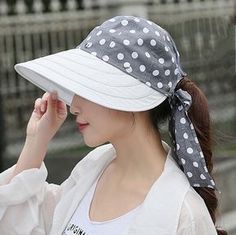 a woman wearing a white and gray polka dot hat