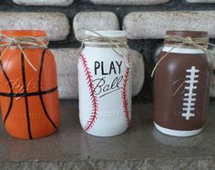 three mason jars decorated with baseball, basketball and play ball designs are sitting next to each other