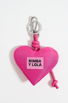 a pink heart shaped keychain with the words bimba y lola on it