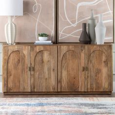 the sideboard is made from wood and has two vases on top of it