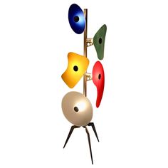 three different colored lamps on a metal pole with black legs and two white balls in the middle