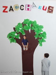 two children standing in front of a paper cut out of a tree with the word zach on it