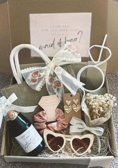 a box filled with lots of different items next to a wine bottle and some cards