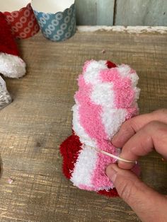 someone crocheting a pink and white teddy bear