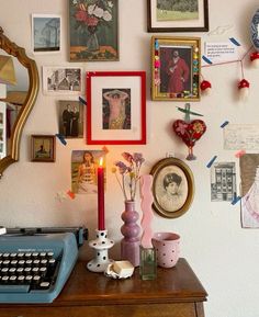 an old fashioned typewriter sitting on top of a desk next to pictures and other items