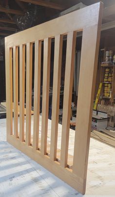 a wooden slatted gate in the middle of a room with shelves and tools