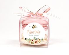 there is a small glass jar with some cookies in it and a ribbon on the top