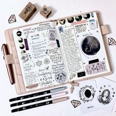 an open notebook with stamps, pens and other items on the page next to it