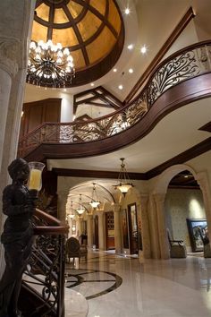 a large foyer with chandelier, marble floors and an ornate staircase leading up to the second floor