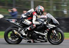 a man riding on the back of a motorcycle down a race track