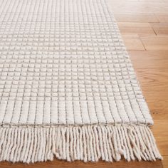 a white rug with fringes on the floor