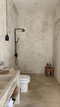 a white toilet sitting next to a bathroom sink under a faucet mounted on a wall