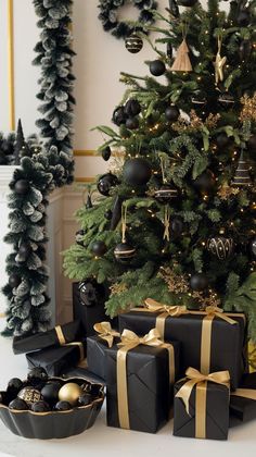 a christmas tree with black and gold presents under it, surrounded by holiday garlands