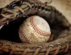 an old baseball in a catchers mitt with the ball inside it's mitt