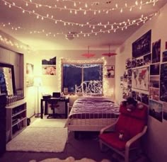 a bedroom with lights strung from the ceiling and pictures on the wall above the bed