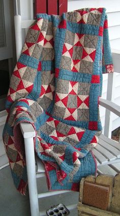 a chair with a quilt on it sitting in front of a door and a window