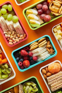 several containers filled with different types of food on an orange surface by luke vandermeer for stockstuffs