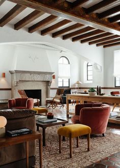 a living room filled with lots of furniture and a fire place in the middle of it