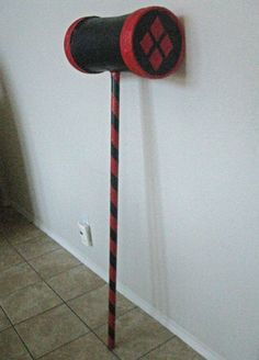 a red and black object is on the wall next to a white wall with tile flooring