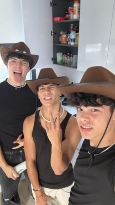 three young men wearing cowboy hats and posing for the camera in a kitchen with their mouths open