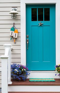 a blue front door with flowers on the steps