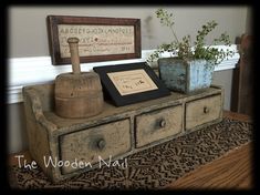 an old dresser with some plants on it and a framed sign above the drawers that says, the wood nail