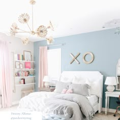 a bedroom with blue walls and white furniture