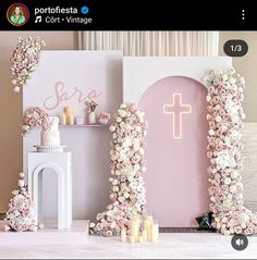 a pink and white wedding set up with flowers on the front, candles in the back