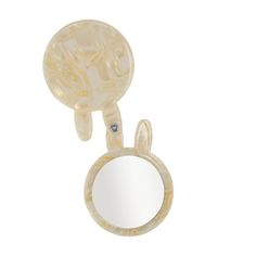 an animal shaped mirror hanging from the side of a white wall mounted mirror with a circular frame