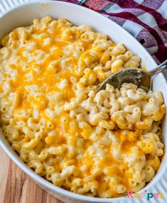 a white bowl filled with macaroni and cheese on top of a wooden table