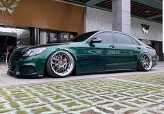 a green car parked in front of a building