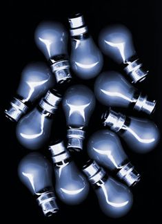 a bunch of light bulbs sitting in the middle of a black background with one bulb turned upside down