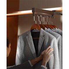 a woman looking at clothes hanging on a rack