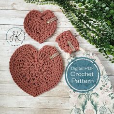 two crocheted hearts sitting next to each other on top of a wooden table