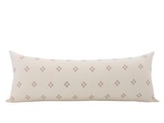 a white and brown pillow with small squares on the front, sitting against a white background