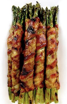 asparagus wrapped in bacon on a white plate