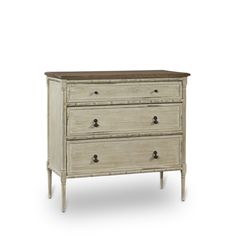 a white dresser with three drawers on it