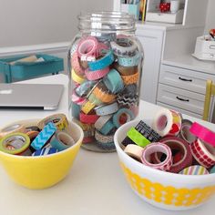 two bowls filled with washi tapes on top of a white table next to a yellow bowl